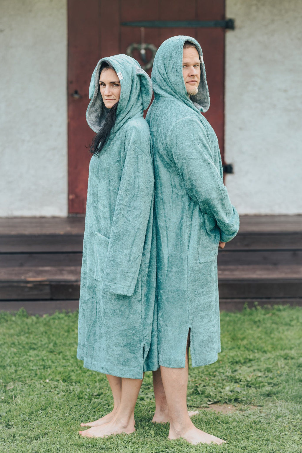 1. Unisex bamboo terry long-sleeve ponchos worn by male and female models outdoors, showcasing hood and pocket design