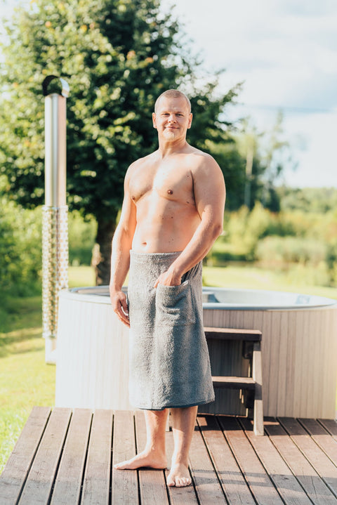 3. Men's gray RÄTT spa wrap worn by male model next to a hot tub, highlighting comfort and style