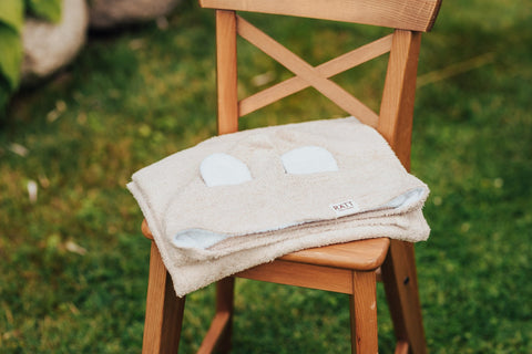 4. Beige RÄTT hooded baby bath towel with rabbit ears, folded on wooden chair