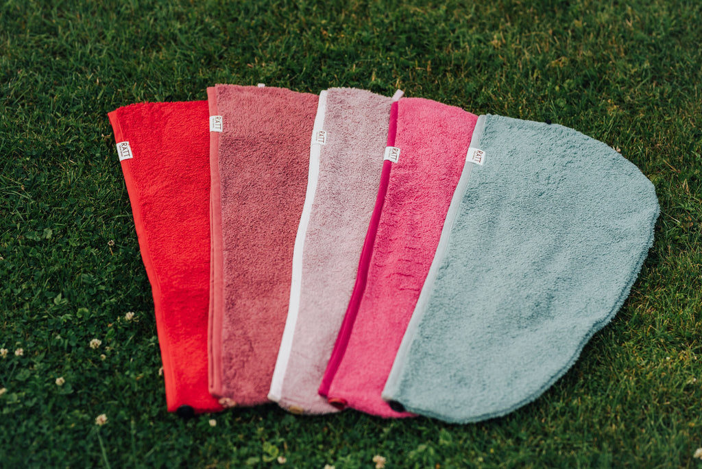 5. Flat lay of RÄTT cotton terry hair wraps in various colors on grass, showcasing color options