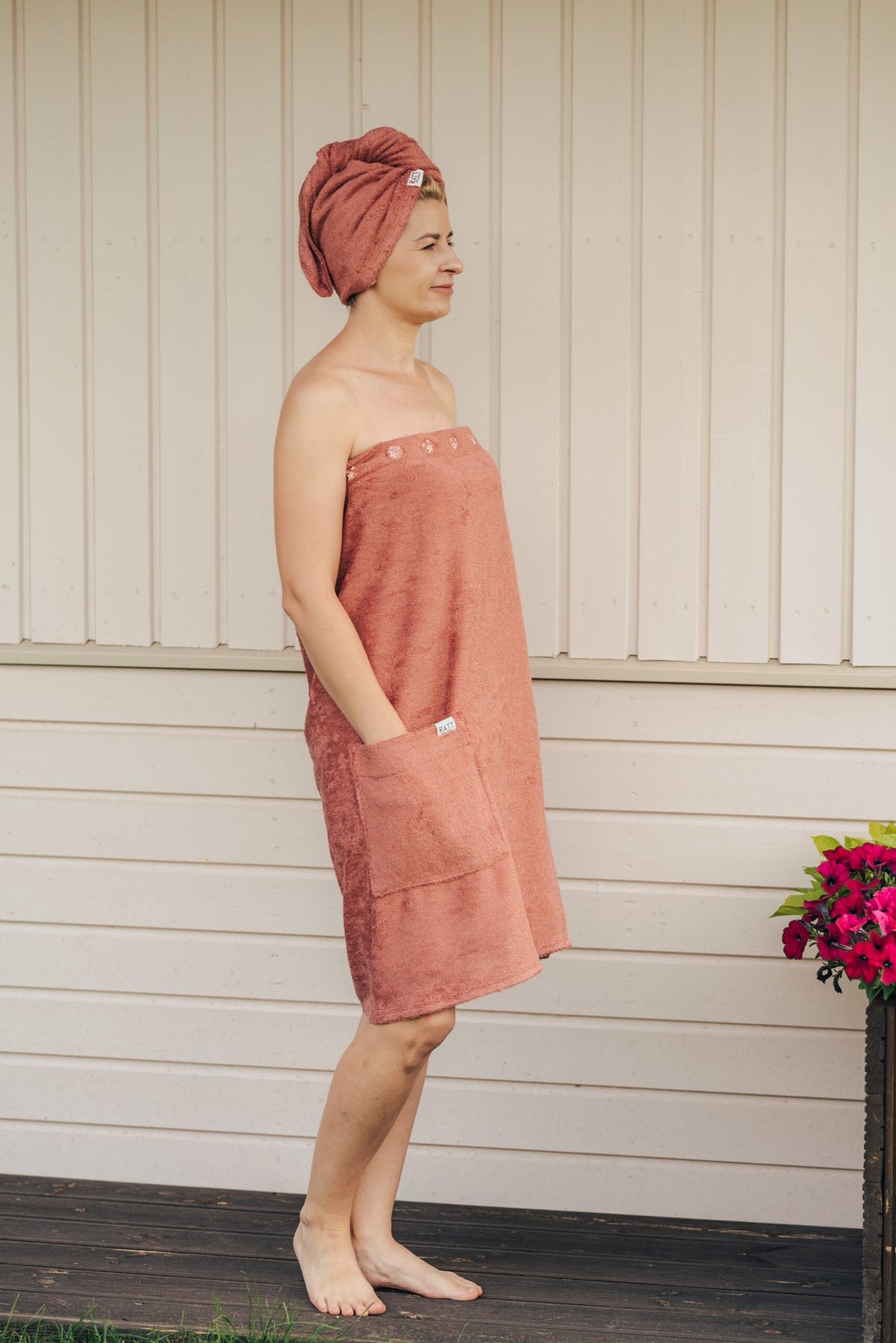 6. Women's golden yellow bamboo terry spa wrap by RÄTT, worn by model outdoors, featuring adjustable fit and pocket