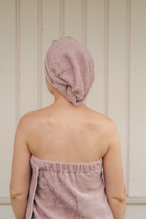 2. Woman wearing RÄTT bamboo terry hair wrap in pink, shown from the back, highlighting secure fit