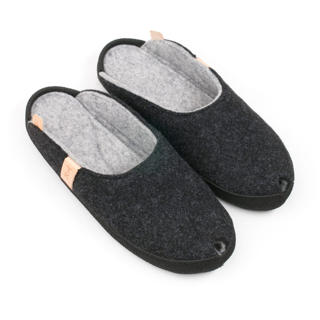 1. Omaking TOKU Brussels dark gray slippers in studio, showing top view with natural lambswool felt and black microfibre sole