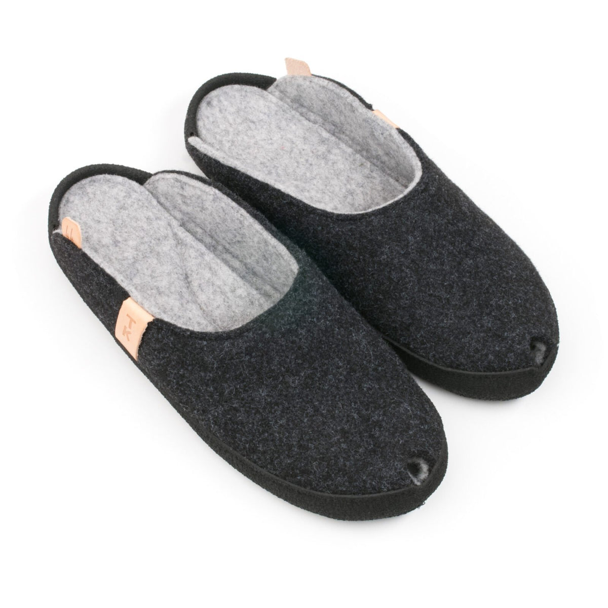 1. Omaking TOKU Brussels dark gray slippers in studio, showing top view with natural lambswool felt and black microfibre sole