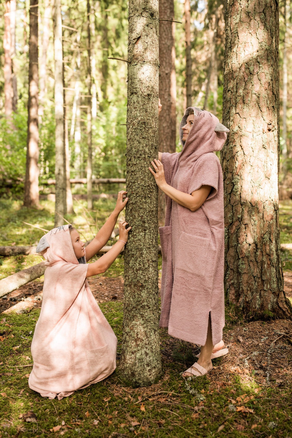 1. Women's and child's pink Short-Sleeve Poncho CAT by RÄTT in bamboo terry, worn in a forest setting