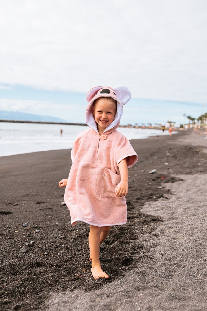 2. Child in pink RÄTT Short-Sleeve Poncho KOALA walking on beach