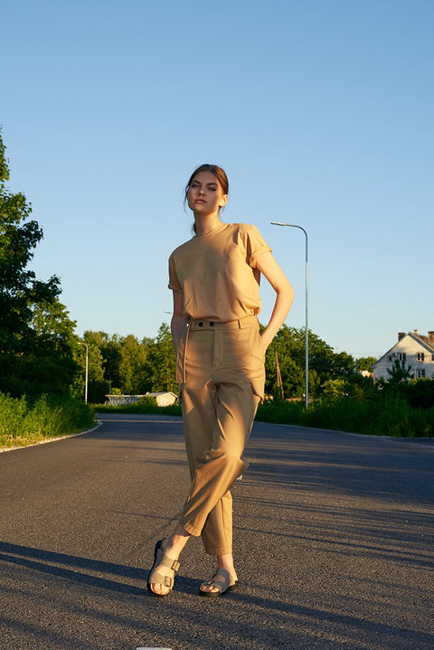 1. Woman wearing Omaking Meeliku grey leather sandals with adjustable buckle straps, standing on a road in a casual outdoor setting