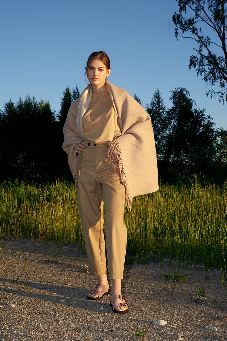 1. Woman wearing Omaking Meeliku pink leather sandals in outdoor setting