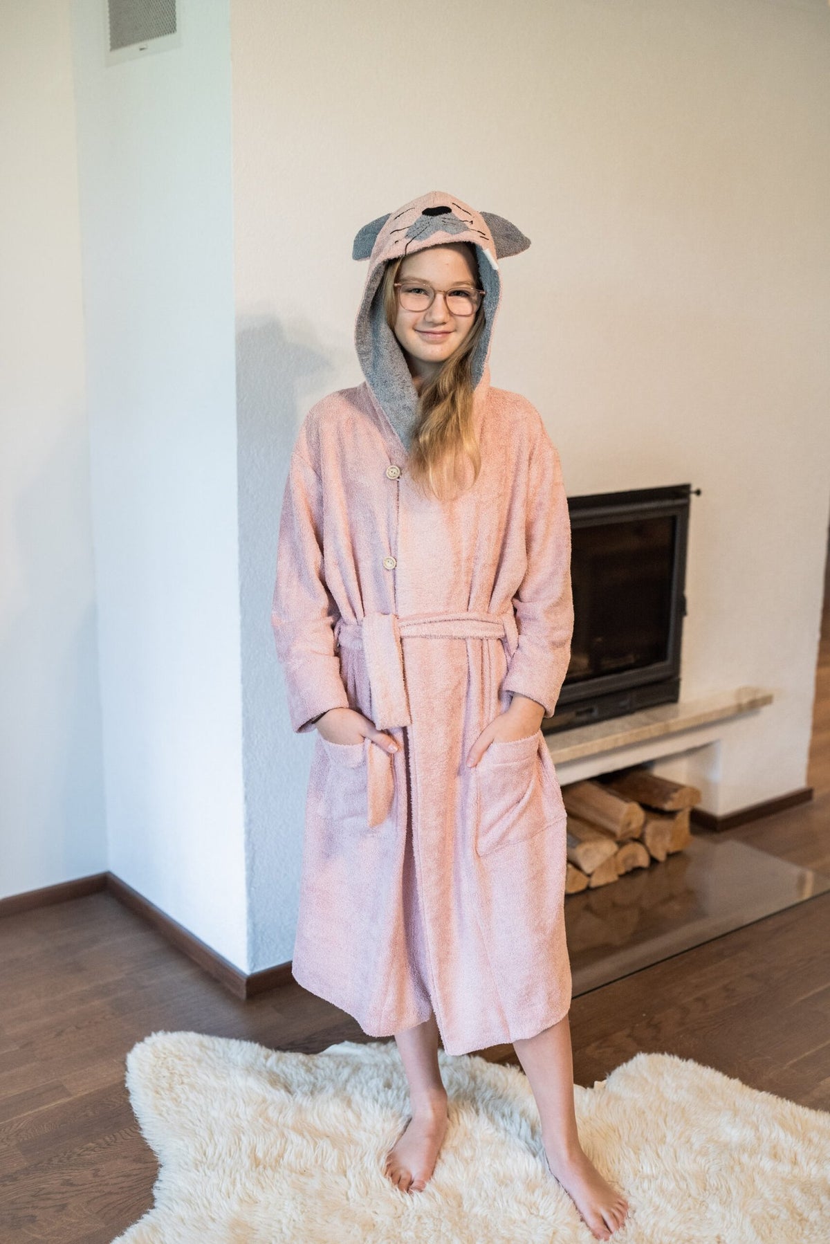 1. Girl wearing pink RÄTT CAT Bamboo Terry Bathrobe with hood and belt, standing indoors