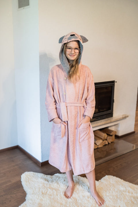 1. Girl wearing pink RÄTT CAT Bamboo Terry Bathrobe with hood and belt, standing indoors