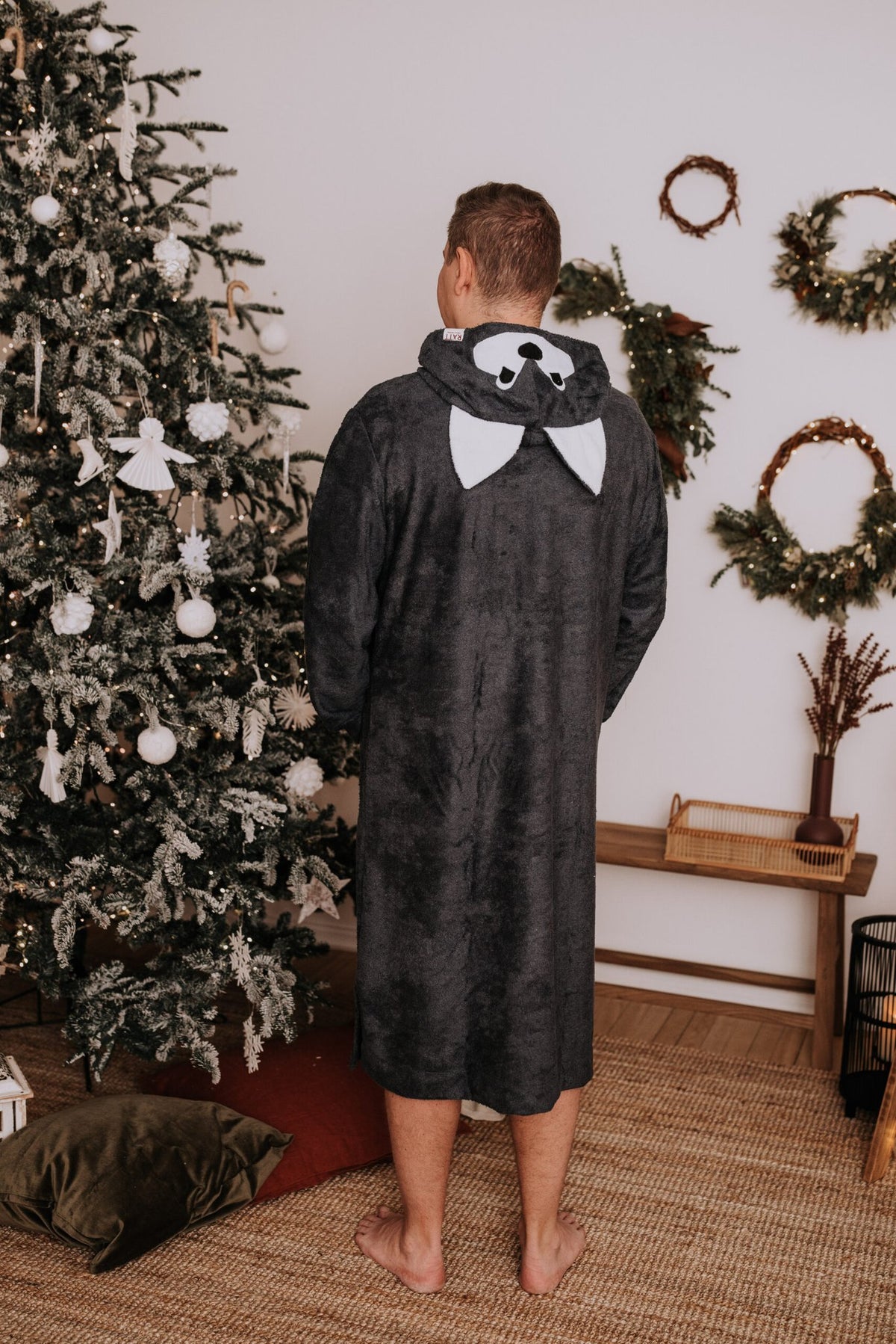 2. Back view of men's long-sleeve poncho WOLF in bamboo terry with hood, shown in cozy home setting