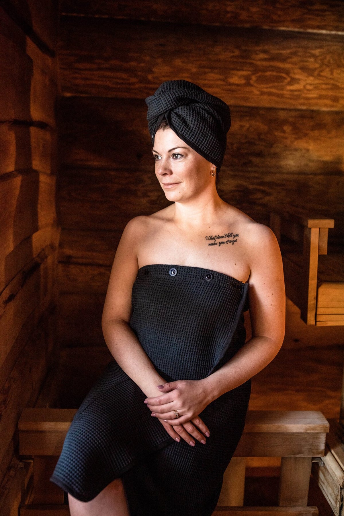 2. Woman wearing RÄTT black cotton waffle hair wrap in a spa setting