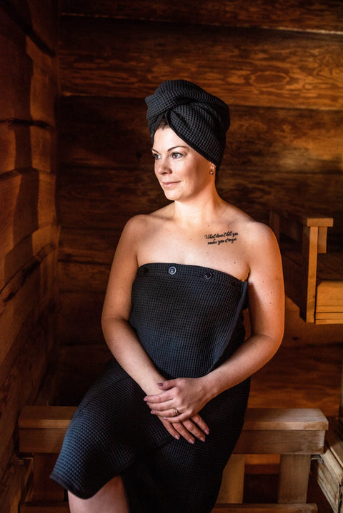 2. Woman wearing RÄTT black cotton waffle hair wrap in a spa setting