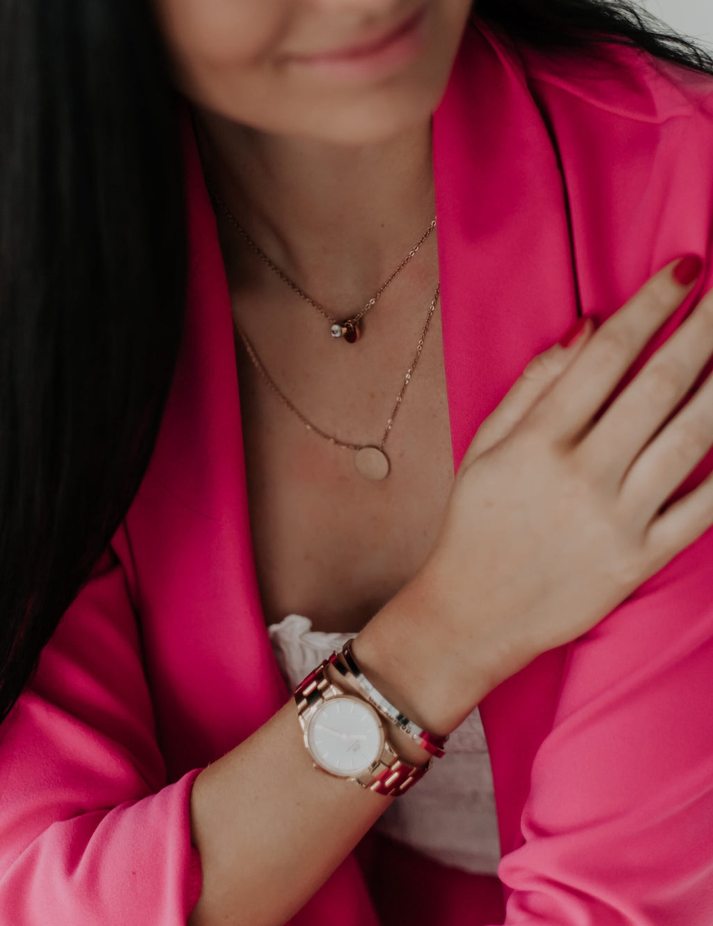 1. Woman wearing Olla's Good Vibes necklace in gold, styled with a pink blazer and watch