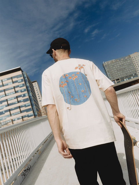 5. Men's heavy-weight premium t-shirt 'Bijutsu Sekai' by Watanabe Seitei, worn by male model with skateboard, showcasing vine illustration, lifestyle setting