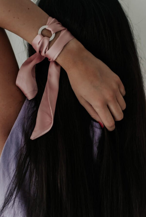 2. Pink silk ribbon bracelet with LOVE ring styled on woman's wrist, shown from back