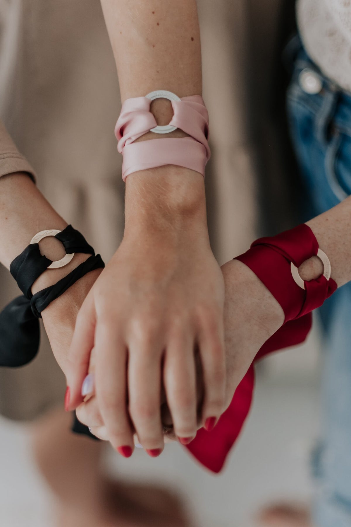 1. Women's silk ribbon bracelets in black, pink, and dark red with engraved 'SOUL SISTERS' rings, worn by three models
