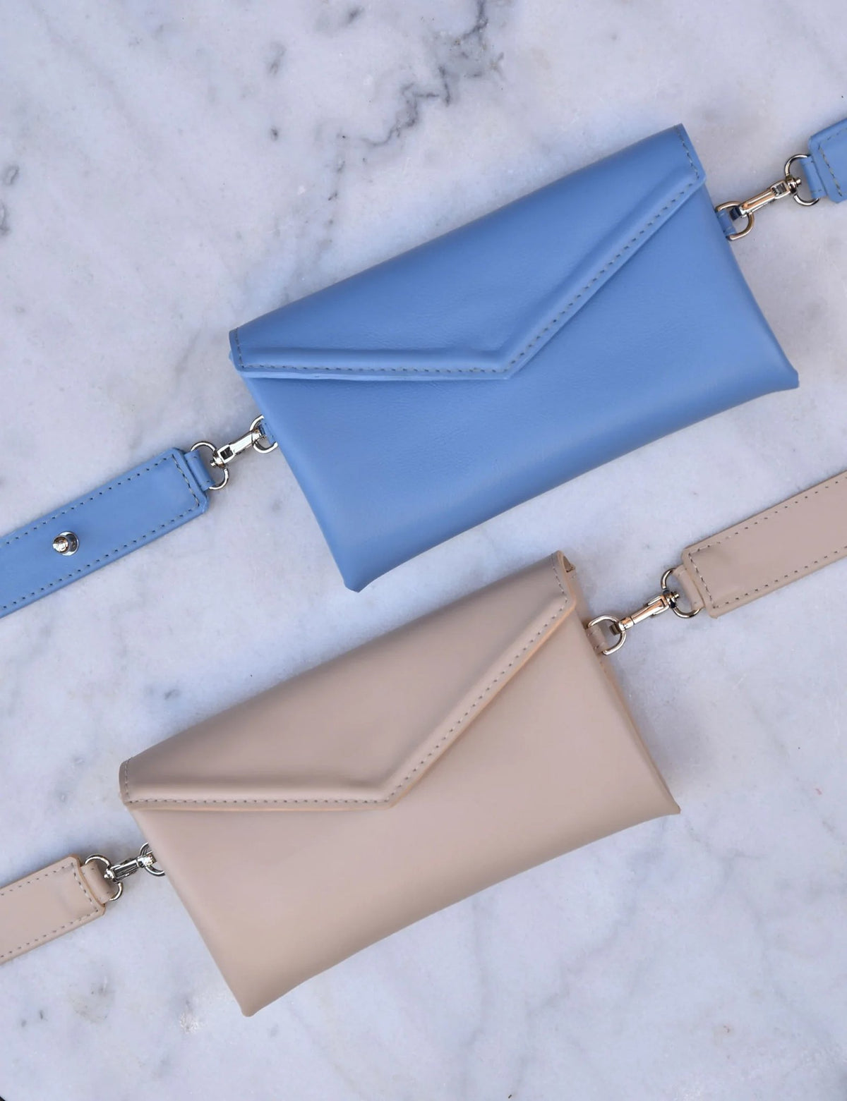 10. Blue and beige leather waist and shoulder bags by Gerda Retter Design, shown flat on marble
