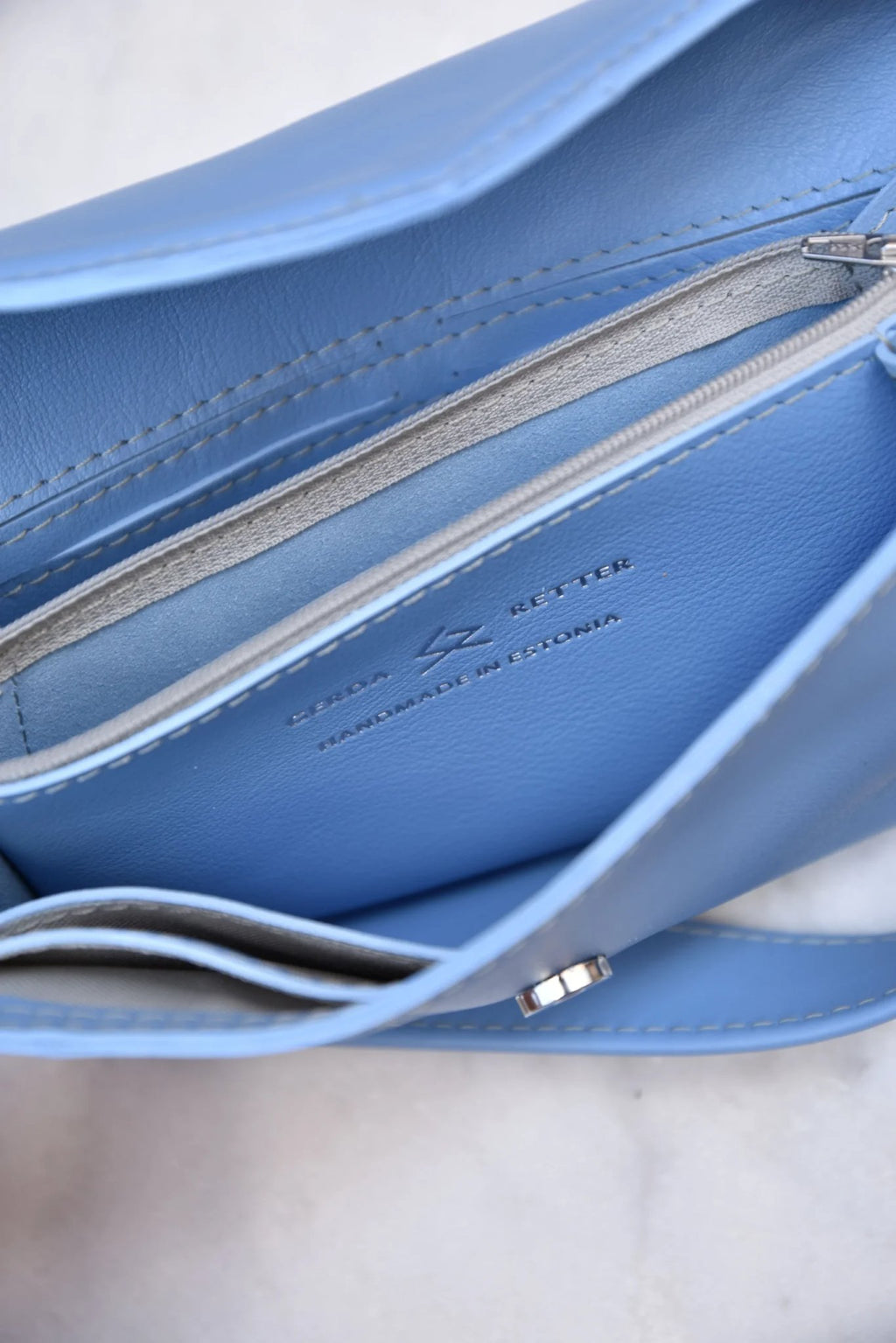 13. Close-up of blue Gerda Retter bag interior showing zippered pocket and branding