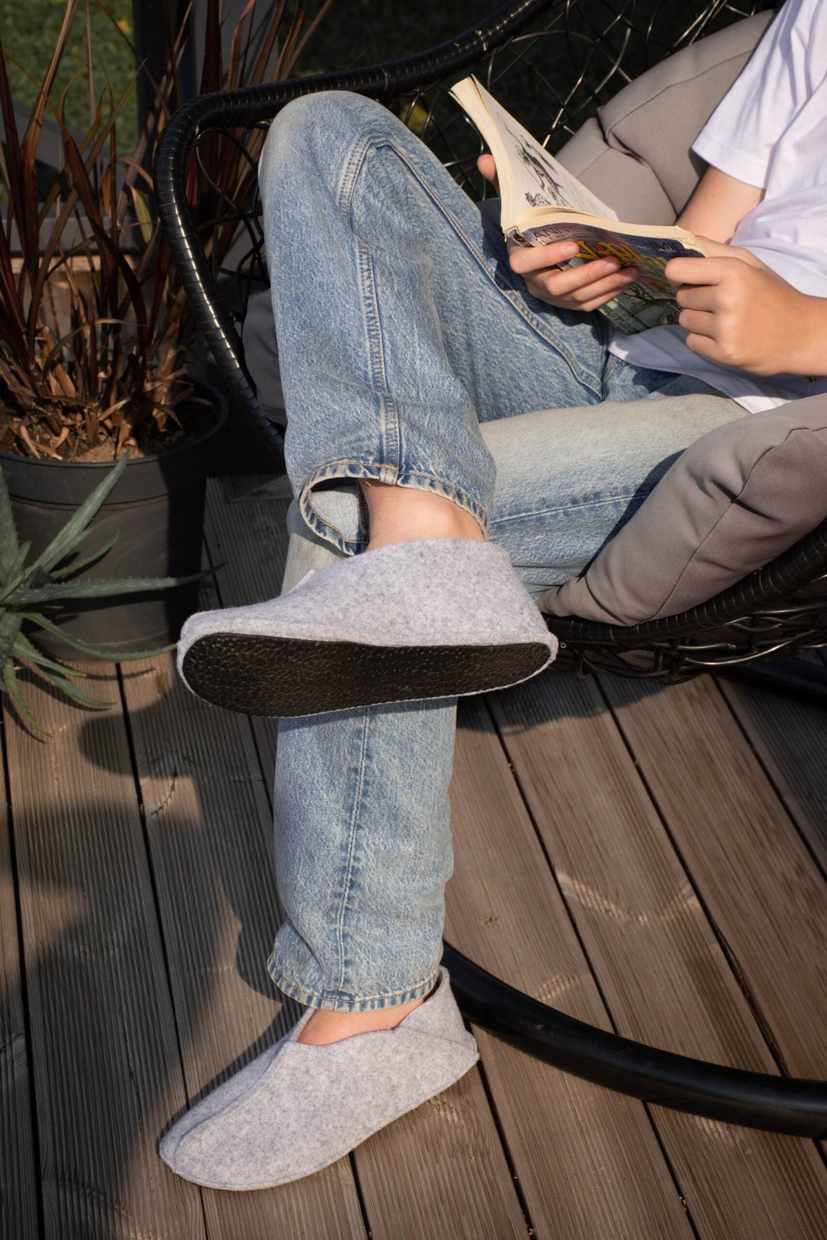 2. Unisex grey Tohkri slippers by Omaking worn by a person reading outdoors, highlighting flexible rubber sole