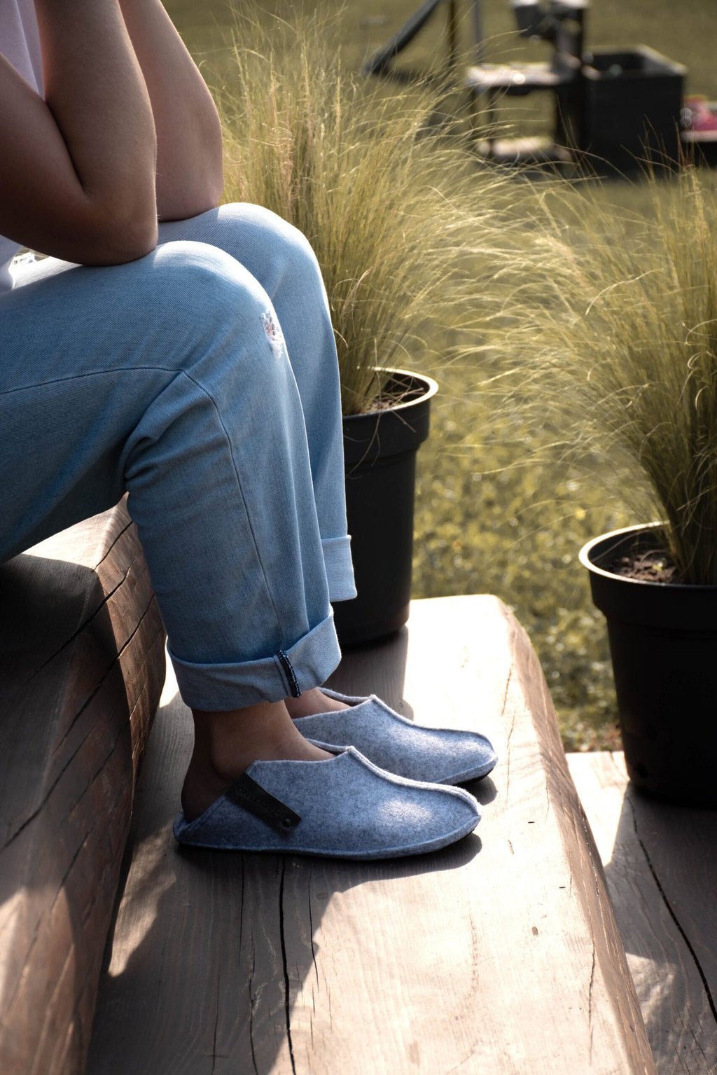 3. Unisex grey Tohkri slippers by Omaking worn by a person sitting on steps, emphasizing convertible heel design