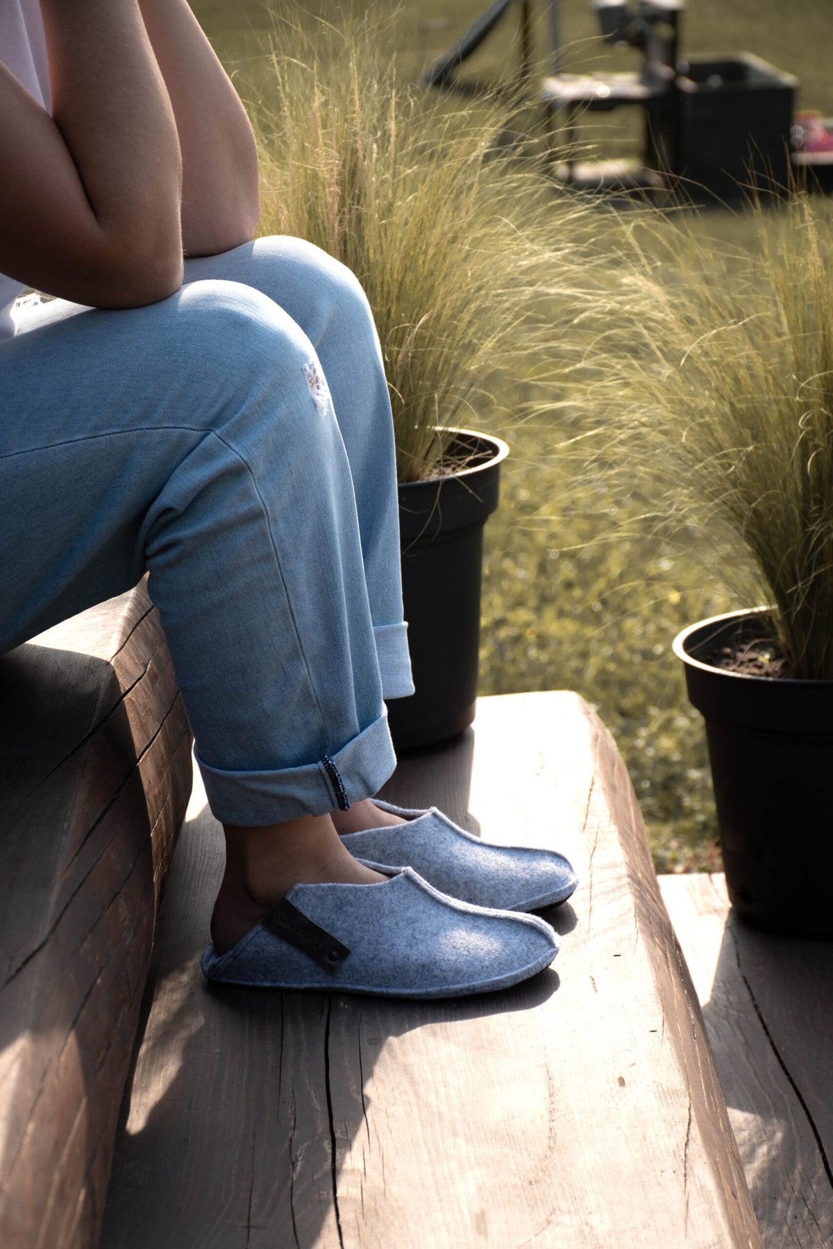 3. Unisex grey Tohkri slippers by Omaking worn by a person sitting on steps, emphasizing convertible heel design