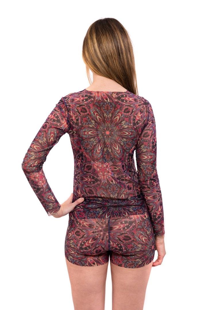 2. Women's tan-through mini leggings and blouse set in terracotta mandala, model posing with hands in hair, studio shot