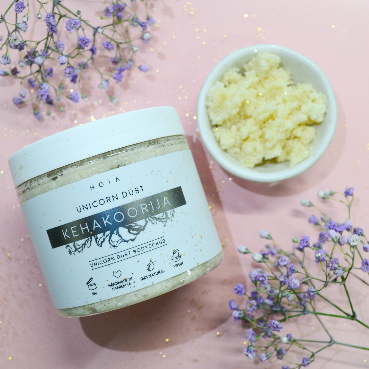 1. HOIA homespa Unicorn Dust body scrub in jar with bowl of scrub on pink background with flowers