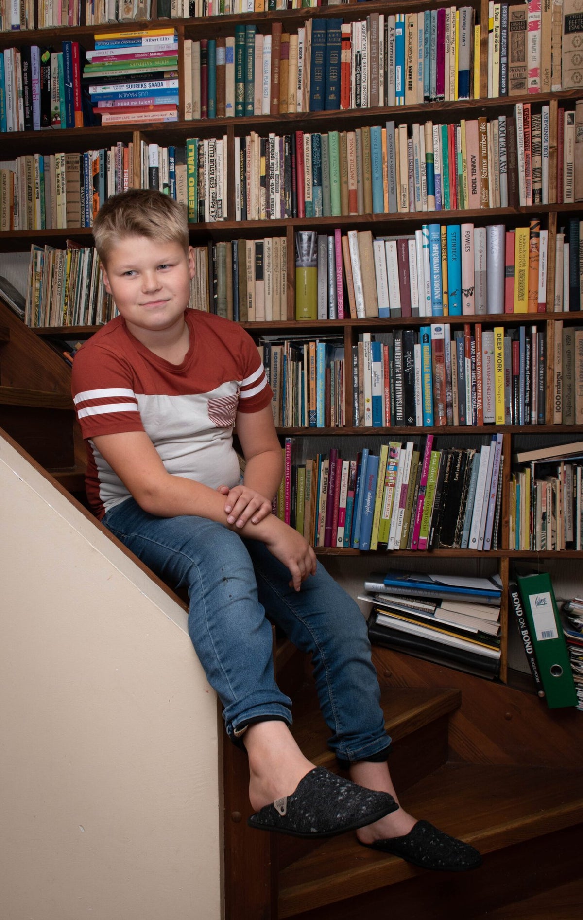 1. Child wearing Omaking dark grey felt slippers in a cozy home library setting