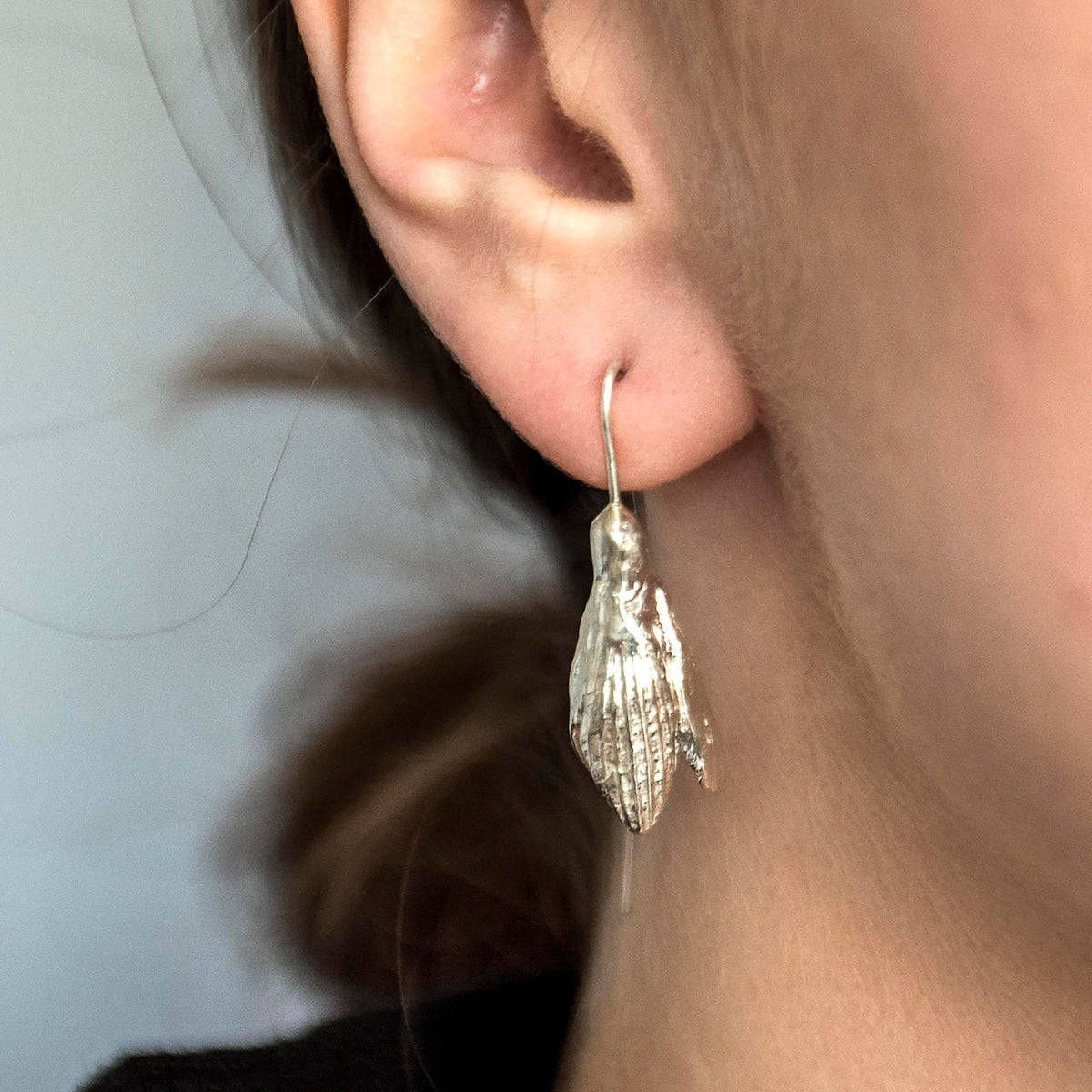 1. Women's SPRING Snowdrops silver earrings by Agnes Veski Jewellery worn by model, showcasing elegant hook design