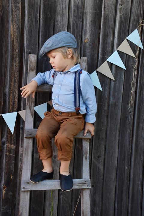 1. Child wearing Hip-Hop Punsa Kids Barefoot Slippers in black, styled with blue shirt and brown pants, sitting on a wooden ladder
