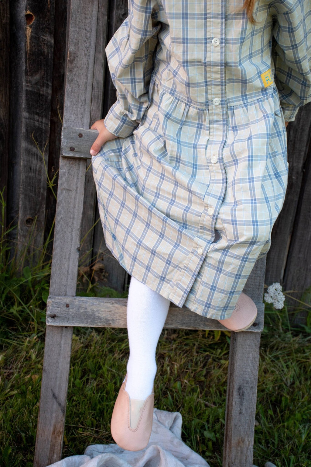 1. Girl wearing Hip-Hop Punsa Kids Barefoot Slippers in beige, climbing a ladder outdoors