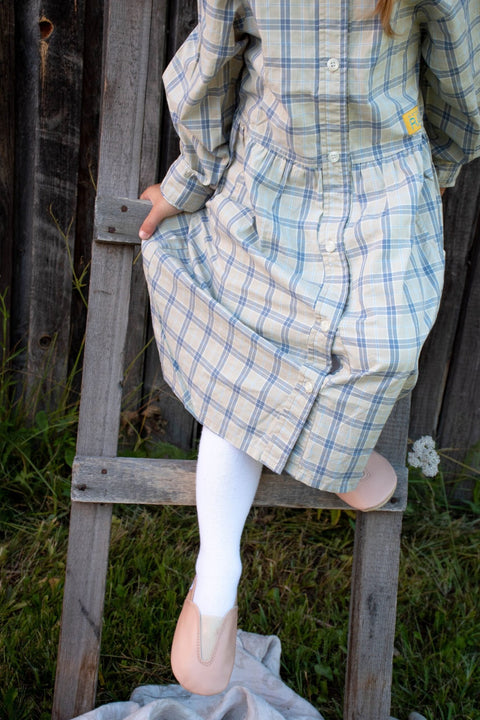 1. Girl wearing Hip-Hop Punsa Kids Barefoot Slippers in beige, climbing a ladder outdoors