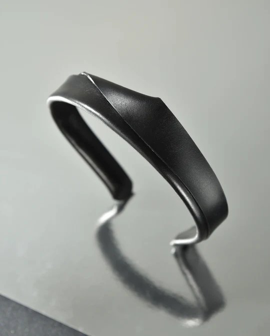 2. Black handmade leather headband by Gerda Retter Design, shown in studio setting