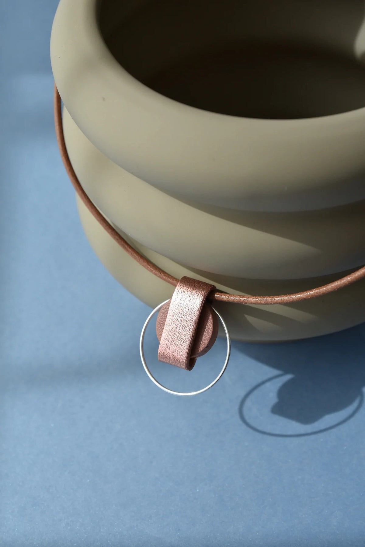 2. Close-up of Gerda Retter Design Luce Mini Handmade Necklace in caramel brown, highlighting geometric pendant and silver details