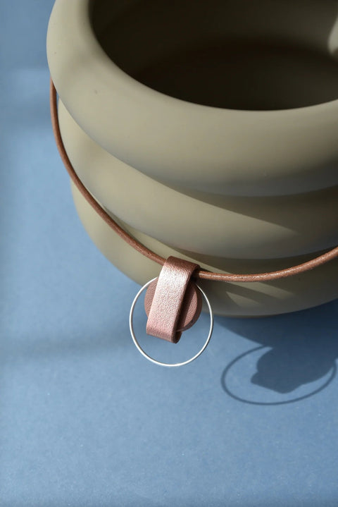 2. Close-up of Gerda Retter Design Luce Mini Handmade Necklace in caramel brown, highlighting geometric pendant and silver details