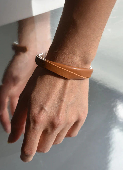 1. Women's caramel brown handmade leather bracelet by Gerda Retter Design, worn on wrist, showcasing adjustable fit and Nordic-inspired elegance