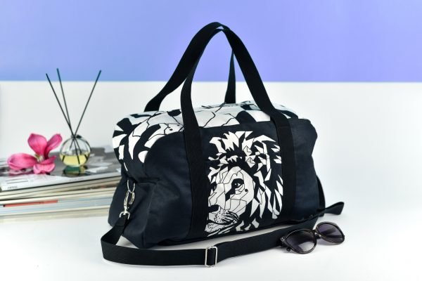 2. Garbanota Travel Bag White Lion in black, studio shot with geometric lion print and shoulder strap