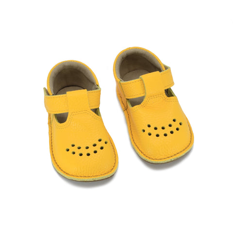 2. Pair of yellow Lusti leather kids' shoes by Omaking with Velcro fasteners and air holes, shown in studio