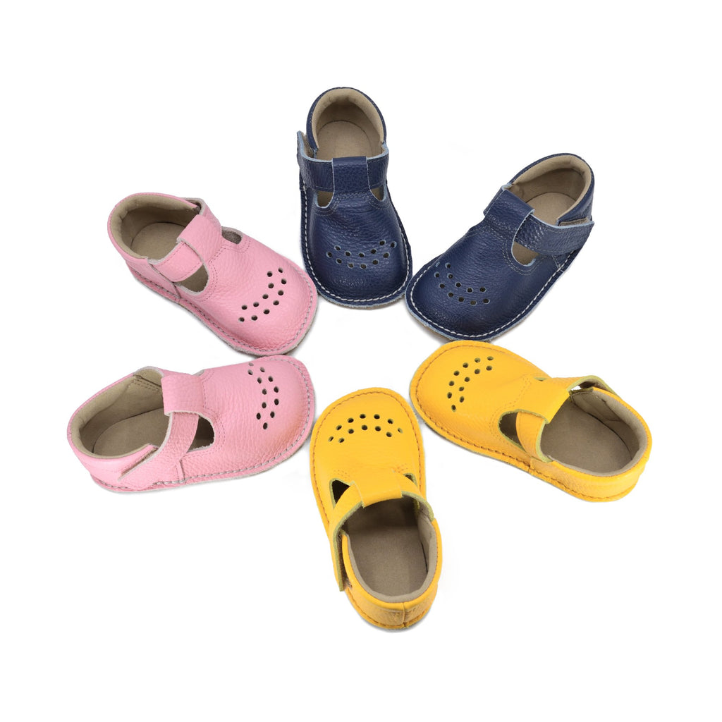 1. Collection of Omaking Lusti leather kids' shoes in dark blue, pink, and yellow, showcasing variety and style