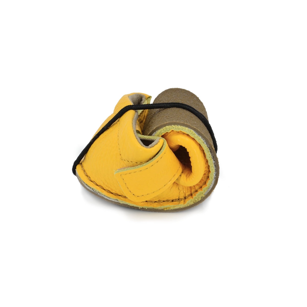 3. Close-up of rolled yellow Lusti leather kids' shoe by Omaking, highlighting flexibility and soft outsole