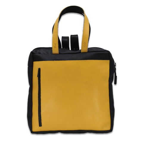 1. Omaking Stockholm Backpack in vibrant yellow with black accents, featuring leather handles and front zipper pocket, shown in studio setting