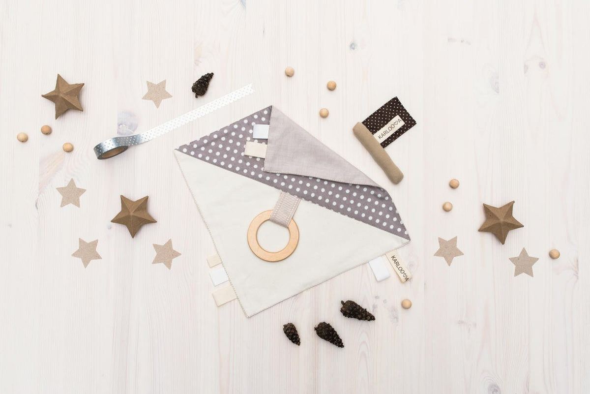 4. Flat lay of Karloova comfort blanket with wooden grabbing hoop and polka dot design on light wood background