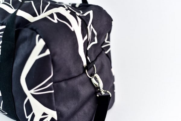 3. Close-up of Garbanota Travel Bag White Wolf in black, showing side view with strap attachment
