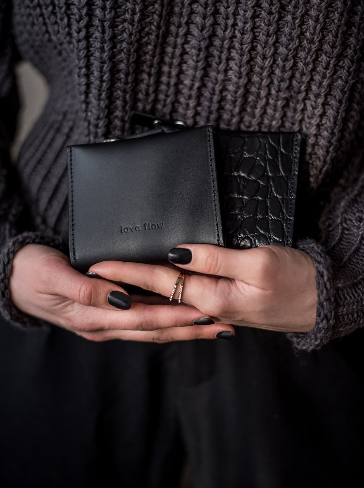 1. Women's hands holding Lava flow Classic Leather Wallet MINI TAAL in black, showcasing elegant design and texture
