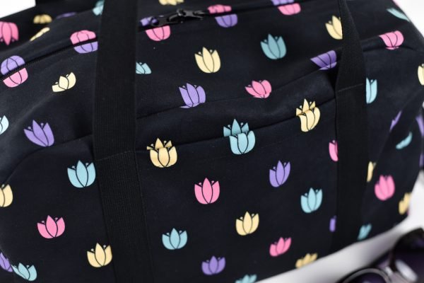 4. Close-up of Garbanota travel bag's exterior pocket with colorful tulip design on black fabric