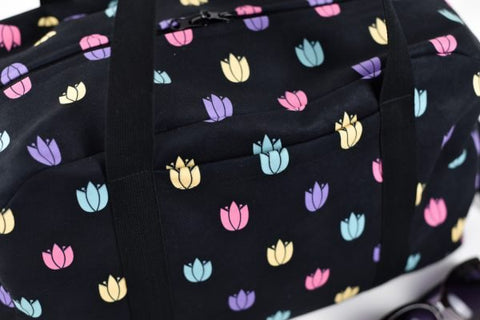 4. Close-up of Garbanota travel bag's exterior pocket with colorful tulip design on black fabric