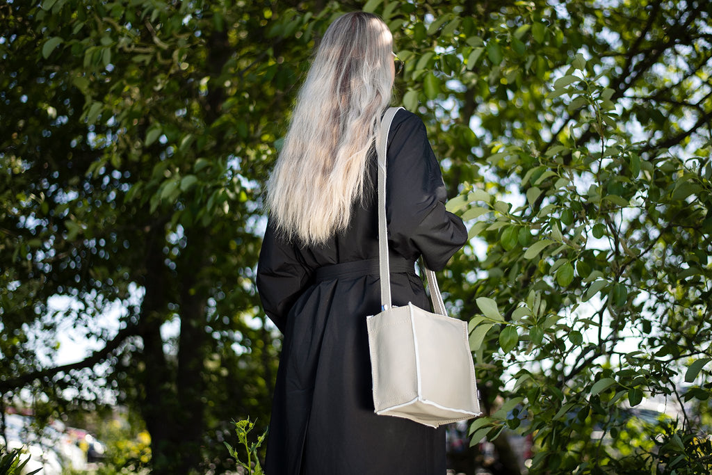 2. Light grey Folk 1 shoulder bag by Trendbag worn by woman in nature, highlighting sustainable fashion