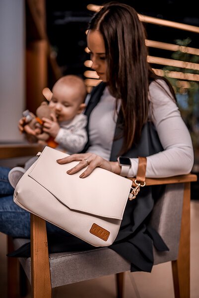 4. Woman sitting with baby, displaying Ally Scandic Älly Handbag in Cappuccino, highlighting versatile design