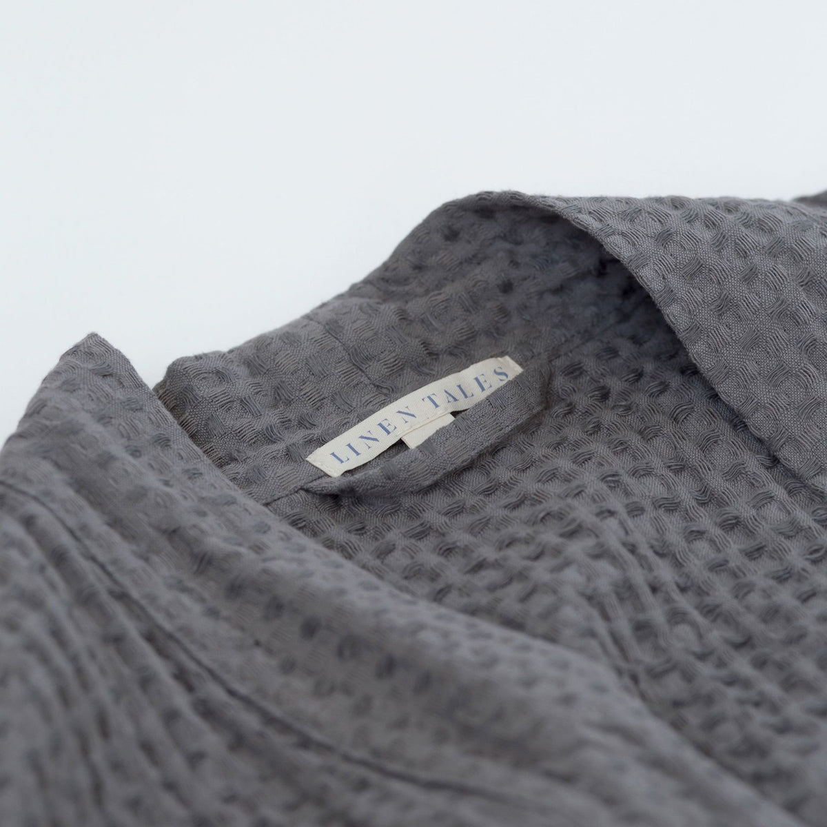 5. Close-up of Linen Tales label on dark grey honeycomb waffle fabric